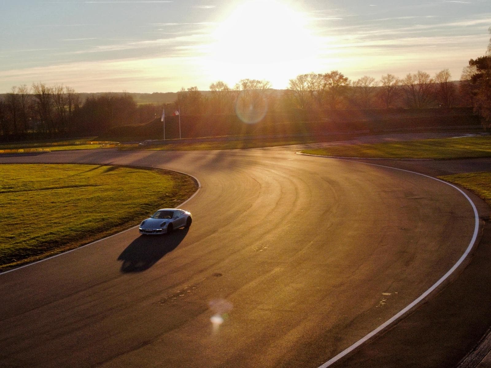 Porsche 911 sur circuit au coucher de soleil
